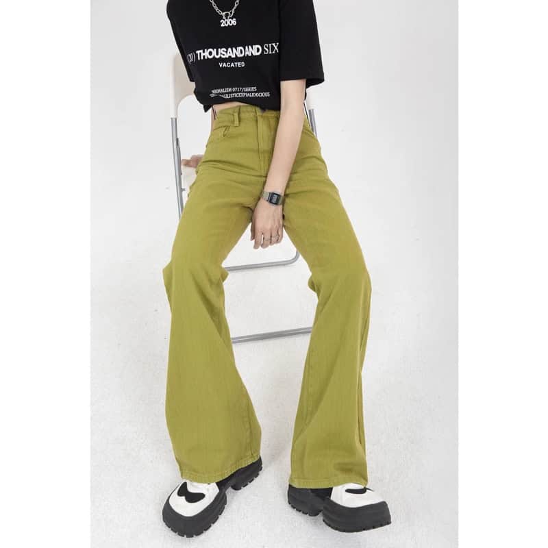 Close-up of trendy yellow high-waisted wide-leg pants worn by a woman, paired with chunky sneakers and a black graphic t-shirt, emphasizing fashionable casual wear suitable for shopping or outings.