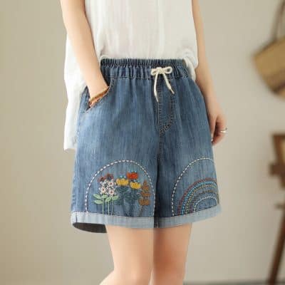 Versatile denim shorts with colorful floral embroidery and rainbow details, perfect for casual summer wear and stylish look. Made with comfortable cotton material and elastic waistband.