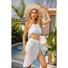 Stylish beach fashion with a trendy white fringed crop top, matching wrap skirt, and wide-brim straw hat for sunny vacation days. Perfect for summer, poolside lounging, or tropical getaways.