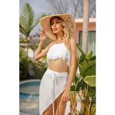 A fashionable woman in white fringe crop top and long skirt with a sun hat, enjoying sunny outdoor setting, showcasing stylish summer vacation clothing from Monalisa Medical Store.