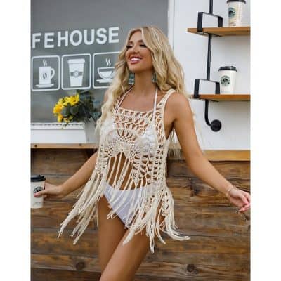 A fashionable crochet beach coverup worn over swimwear, perfect for summer days and beach outings. Made with intricate crochet patterns and fringe details for a stylish, breezy look.