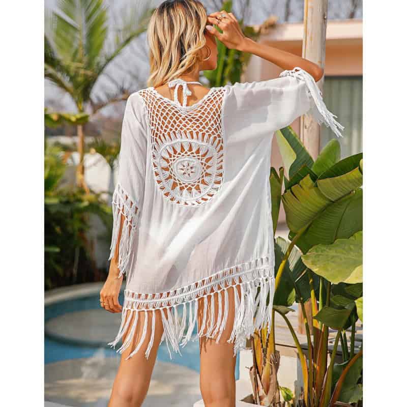 Stylish white beach cover-up with crochet design and fringe detail. Perfect for beach or poolside look, offering a chic and breathable summer style.