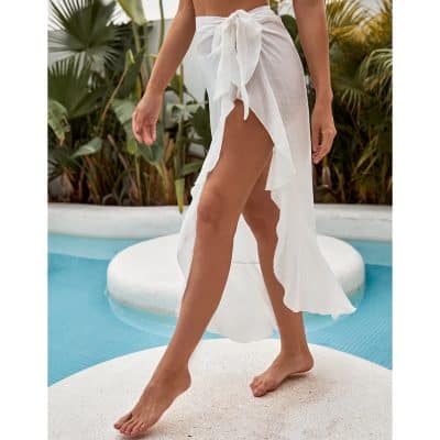 Elegant white beach cover-up with high slit, lightweight fabric, and stylish bow tie at waist. Perfect for poolside or seaside beach vacations.