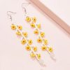 Bright yellow and white floral beaded earrings, perfect for accessory styling and fashion statements. Handcrafted jewelry ideal for casual and party wear.