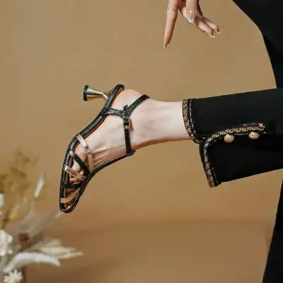 Elegant black and gold strappy sandals perfect for fashion-forward footwear. Featuring a sleek design and comfortable heel, ideal for dressing up or casual wear.