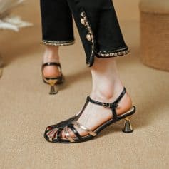 Elegant black t-strap high heels with metallic accents, perfect for fashion-forward women. Comfortable and chic, ideal for formal occasions or upscale outings.