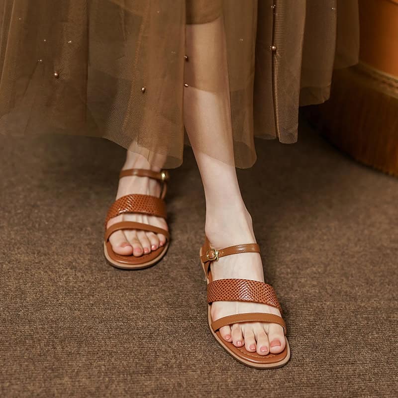 Close-up of women's fashionable brown leather sandals with adjustable straps, perfect for comfort and style.