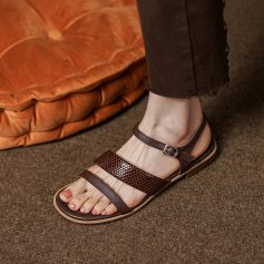 Close-up of stylish brown women’s sandals with multiple straps and a buckle, perfect for summer or casual wear, showcasing comfort, fashion, and quality footwear.