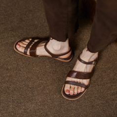 Close-up of women's brown leather sandals with ankle strap, suitable for casual and everyday wear, displayed on textured brown carpet floor, from Monalisa Store.