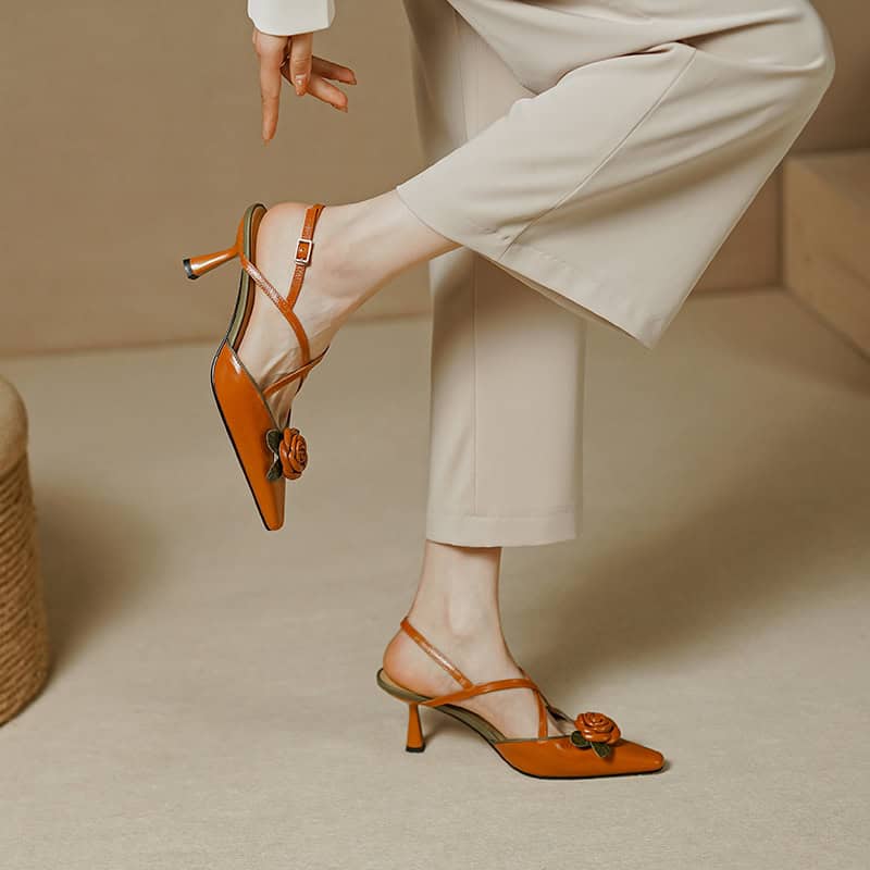 Stylish tan leather high heels with floral embellishments, perfect for fashion-forward occasions. Featuring delicate straps and a modest heel, blending comfort and sophistication seamlessly.