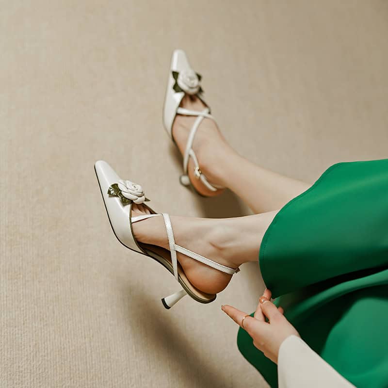 Beautiful white high heels with floral embellishments, perfect for formal occasions and stylish outfits. Comfortable and chic footwear designed for women seeking elegance.