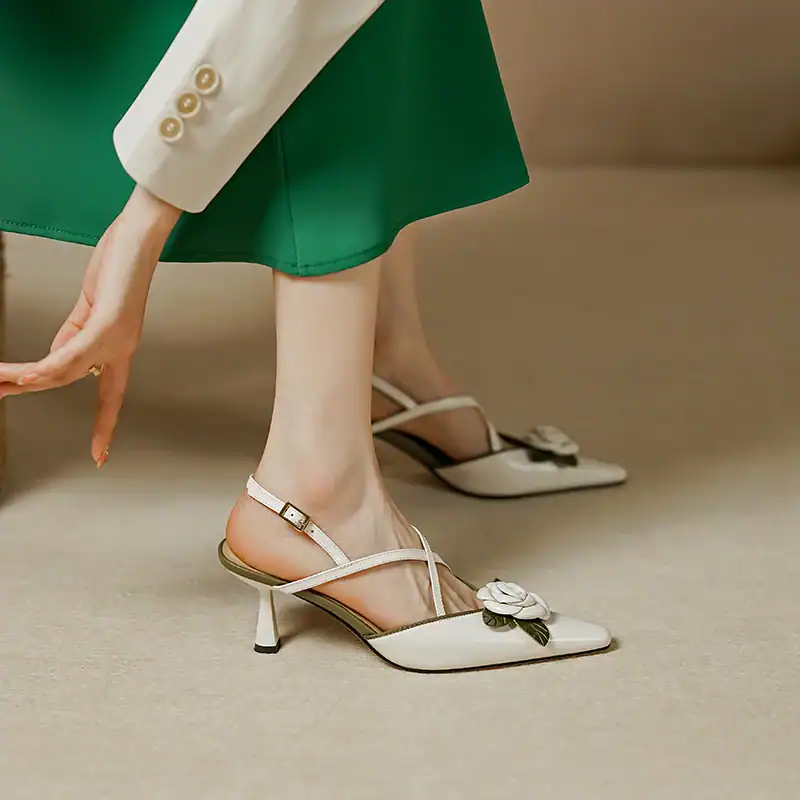 Stylish white heels for women featuring floral embellishments, comfortable straps, and pointed toes. Perfect for fashionable occasions and elegant looks.