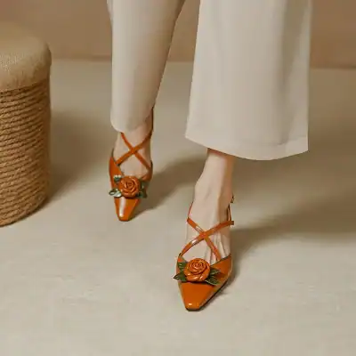 Stylish orange women’s high heels with floral rose embellishment, perfect for fashion-forward outfits, available at Monalisa Store for the latest in women's footwear.