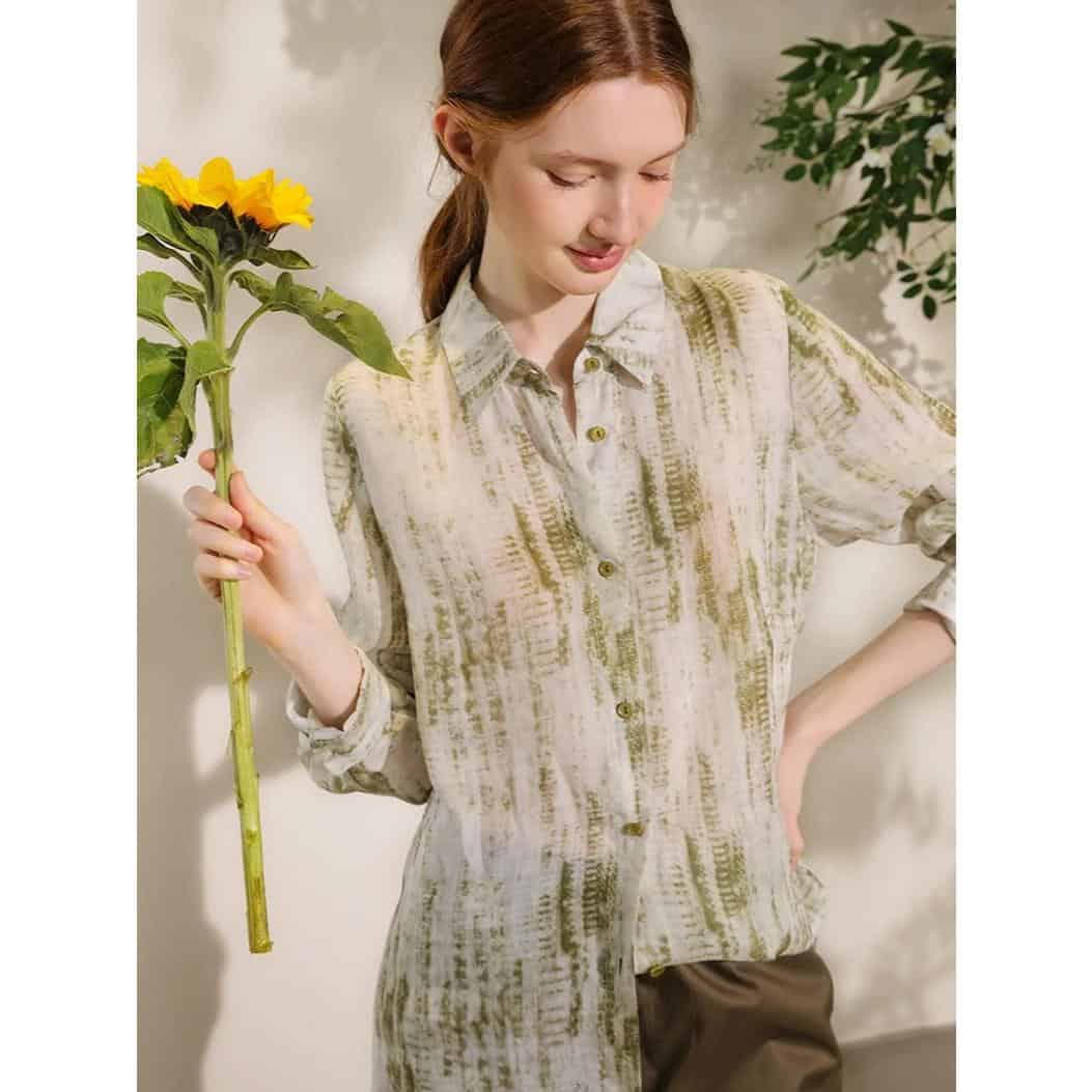Bright sunflower held by a woman with red hair in a stylish patterned shirt in Monalisa Medical Store. The image captures a cheerful, modern, health-focused mood with natural light ambiance.