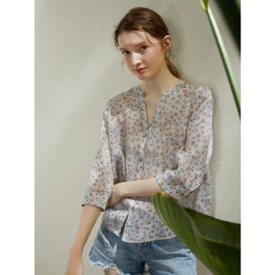Woman wearing casual floral blouse showcasing trendy optical fashion.