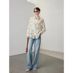 Fashionable woman wearing trendy sunglasses, pastel shirt, and wide-leg jeans, showcasing modern casual fashion from Monalisa Store for style-conscious shoppers.