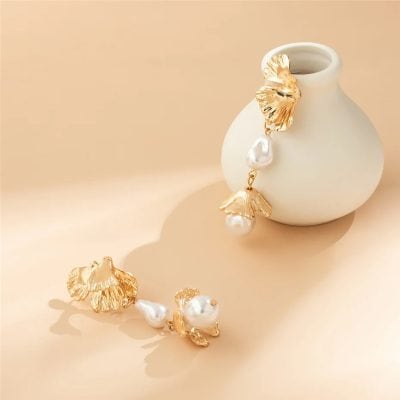 Luxury pearl and gold leaf statement earrings with intricate design, perfect for fashionable jewelry lovers. High-quality craftsmanship in a stylish jewelry piece for women.