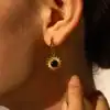 Delicate gold sunburst earring with black center stone, perfect for elegant jewelry lovers and special occasions.