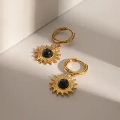 Elegant gold sunburst earrings featuring a central black stone, perfect for stylish accessories. Shop high-quality jewelry at Monalisa Store for a luxurious look.
