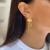 Gold jellyfish earrings with flowing tentacles, stylish accessories for women. Unique jewelry design perfect for fashionable outfits and special occasions.