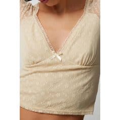 Delicate beige lace sleepwear top with a satin bow at the neckline, perfect for comfortable and stylish loungewear.
