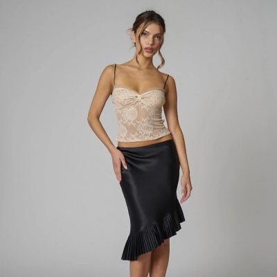 Lace top with floral pattern paired with a sleek black midi skirt featuring pleated hem, perfect for trendy women’s fashion and special occasions.