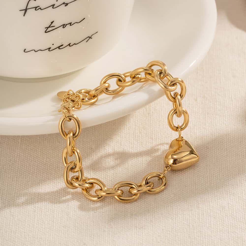 Luxurious gold chain bracelet with heart pendant, perfect for fashion-forward individuals seeking high-quality accessories. Ideal for gifting or accessorizing daily outfits.