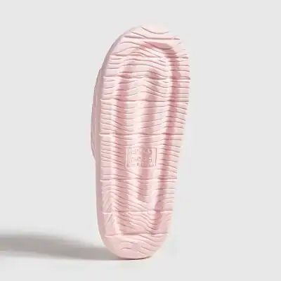 Soft pink slip-on slippers with textured soles for comfort and support. Perfect for indoor use, providing a cozy and stylish footwear option.
