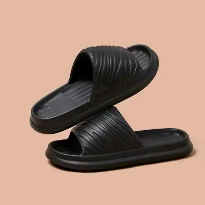 Comfortable black slide sandals with textured straps and cushioned soles for casual wear and easy slip-on style. Perfect for everyday comfort and convenience.
