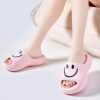 Pink smiley face slippers with open toe design, perfect for relaxation and indoor wear, featuring a cheerful smiley face graphic for a fun, comfortable footwear experience.