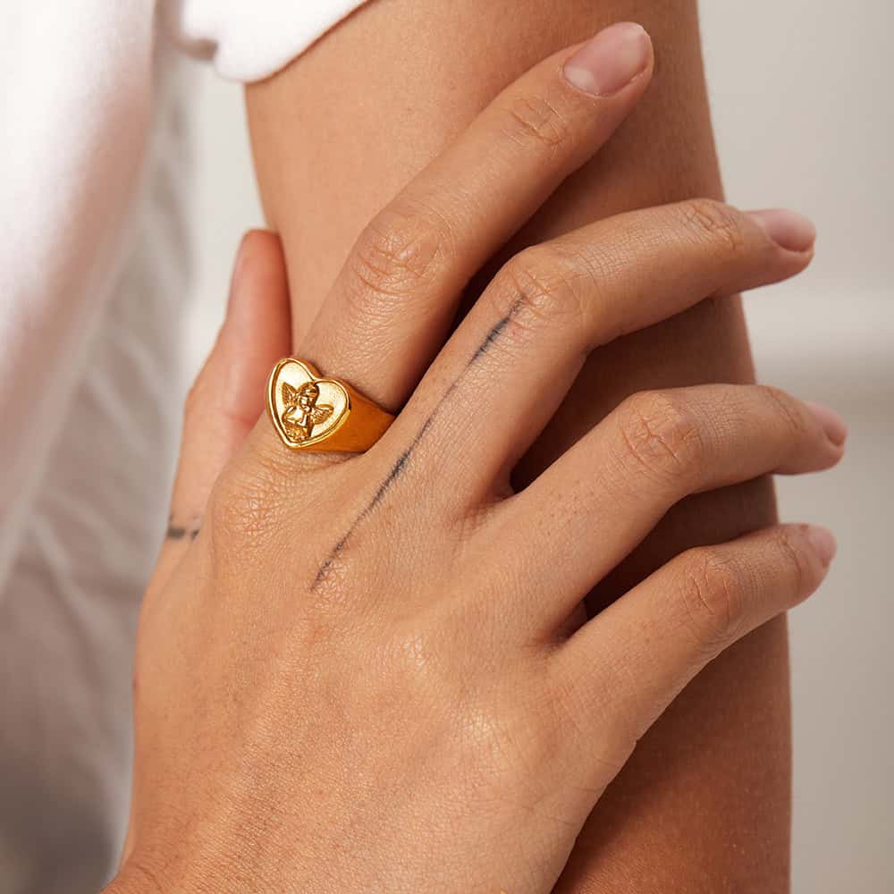 Close-up of a gold ring with a butterfly design on a woman's finger, showcasing jewelry options from Monalisa Store for elegant and stylish accessories.