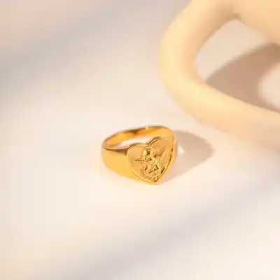 Shiny gold ring with angel engraving, ideal for jewelry enthusiasts. Fine craftsmanship and unique design make this ring a great gift or personal accessory from Monalisa Medical Store.