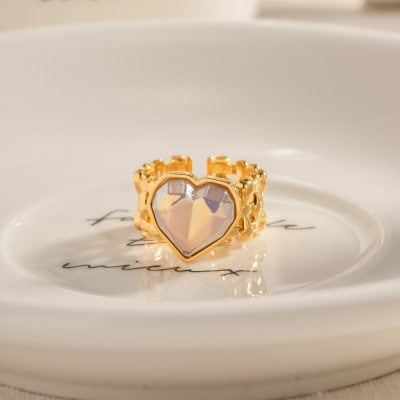Gold heart-shaped ring with a large iridescent gemstone, stylish accessory, ideal for women seeking unique jewelry.
