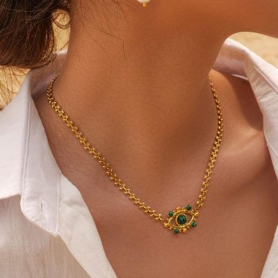 Close-up of a gold chain necklace featuring a pendant with green stones, styled beautifully for women. Perfect for enhancing your jewelry collection at Monalisa Store.