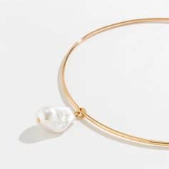 Close-up of a gold loop necklace featuring a dangling white pearl, ideal for jewelry lovers. Perfect accessory for a sophisticated look, available at Monalisa Medical store.