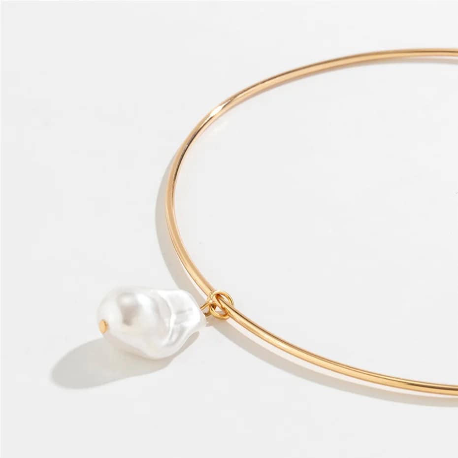 Close-up of a gold loop necklace featuring a dangling white pearl, ideal for jewelry lovers. Perfect accessory for a sophisticated look, available at Monalisa Medical store.