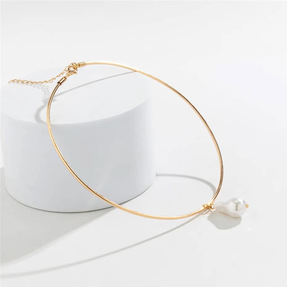 Gold choker necklace with a dangling pearl for stylish elegance and sophistication. Perfect accessory for formal or casual fashion statements.