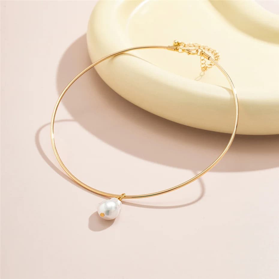 Delicate gold choker necklace featuring a single pearl pendant, ideal for stylish women seeking luxurious jewelry options. Perfect for enhancing any outfit with a touch of sophistication.