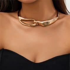 A close-up of a stylish metallic gold choker necklace worn on a woman's neck, showcasing luxury fashion and jewelry trends.