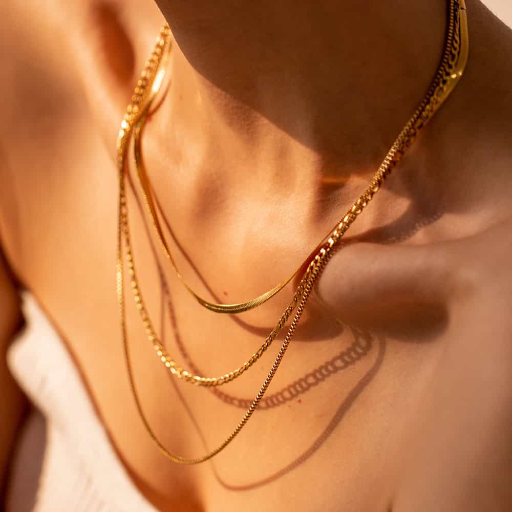 Gold jewelry necklaces displayed on a woman's neck, featuring different styles and lengths that highlight sophistication, quality, and elegance, ideal for accessorizing everyday outfits or special occasions.