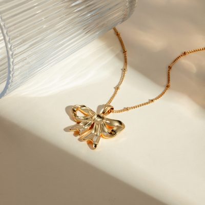 Delicate gold necklace featuring a bow pendant, perfect for stylish accessorizing. Shop luxury jewelry collection at Monalisa Store for timeless elegance.