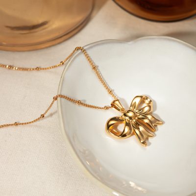 Delicate gold necklace with a charming bow pendant, perfect for elegant jewelry collections and gift-giving. Crafted with high-quality gold for a luxurious finish.