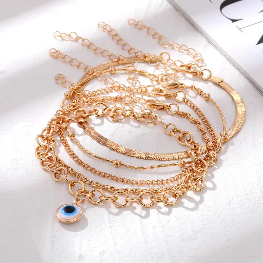 Elegant gold layered necklace set featuring an evil eye charm, perfect for accessorizing and adding a touch of protection and style to your outfit.