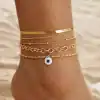 Stack of delicate gold bracelets with a blue evil eye charm on a woman's wrist, perfect for stylish accessorizing and protection.