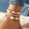 Delicate white shell and gold bracelets, perfect for beach-inspired jewelry and casual summer accessory styling.