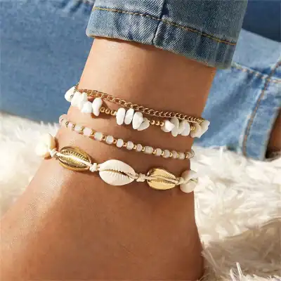 Delicate white shell and gold bracelets, perfect for beach-inspired jewelry and casual summer accessory styling.