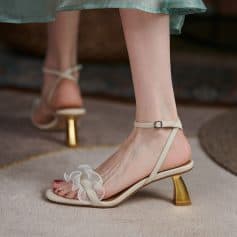 High heel open-toe sandals with ankle strap and ruffled toe detail, perfect for stylish women.