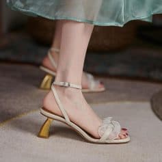 Stylish women's high-heeled sandals with ankle straps, delicate ruffles, and gold accents, perfect for fashion-forward occasions. Comfortable yet chic footwear from Monalisa Medical Store.