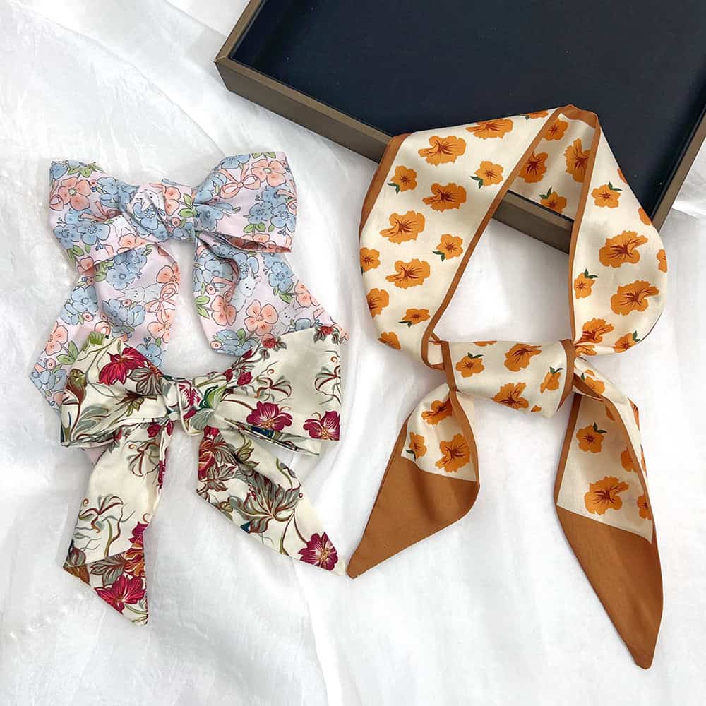 Colorful floral patterned scrunchies and bows ideal for stylish hair styling, available at Monalisa Medical Store. Perfect for casual and formal looks, enhancing your hairdo effortlessly.