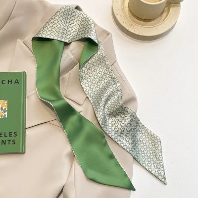 Luxurious silk scarf with houndstooth pattern and vibrant green interior, perfect for stylish accessories and versatile outfits.